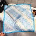 Detailansicht eines seidigen quadratischen Schals mit blauem geometrischem Kreismuster - 65x65cm / Seeblau