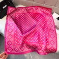 Vista dettagliata di un foulard in seta magenta a pois su sfondo morbido - 65*65cm / rosa acceso