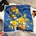 Detailed view of dark blue floral silk scarf displayed on white plush rug with handbag - Bandana / Dark Blue