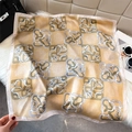 Macro detail of silk scarf with geometric floral print and delicate rolled hem - 65*65cm / Light gold