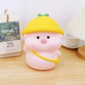 Pink cartoon pig piggy bank with a yellow hat and bag on a warm wooden desk - Doudou Piggy Bank