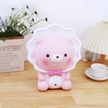 Luce notturna a forma di orso rosa con colletto a fiori su una scrivania accogliente - Salvadanaio Orso Rosa