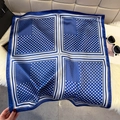 Dettaglio foulard in seta a pois blu e bianchi con bordo geometrico su ecopelliccia - Blu scuro