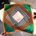 Flat lay of a silk square scarf with orange borders and green geometric stripe patterns - Geometric Color Block Style (W-499) / Green