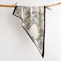 Foulard en soie beige à motif paisley et bordures noires suspendu à une branche de bois - Blanc