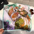 Artistic lotus oil painting silk scarf displayed with luxury accessories on plush rug - Emerald Green