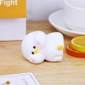 Cute white duck ornament with pink cheeks on a wooden desk with a yellow gift box - White Duck Ornament