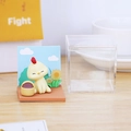 Miniature chicken figurine with sunflower base and acrylic display case on desk - Chicken