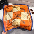Detail van luxe oranje zijden sjaal met paardensportmotieven en een chique kettingprint - Oranje / 65*65cm