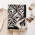 Detail van winter sjaal met zwarte golfpatronen en beige franjes op een witte tafel - Zwart