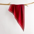Deep red silk scarf with letter prints hung on a wooden branch against a white background - Red