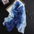 Écharpe élégante en soie dégradé bleu avec motifs floraux sur un plateau doré décoratif - Bleu + Blanc