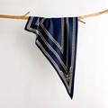 Close-up of elegant navy silk scarf with vintage crest pattern draped on a dry branch - Dark Blue