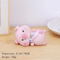 Cute pink resin pig figurine with blue bow and luck bag for desk decor, 8.2x4.7x5cm size - Lying Peach Pig (2572-1B)