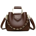 Brown leather bucket handbag with gold metal handle and amber chain strap detail - Brown