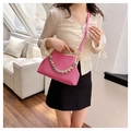 Detail of rose red woven bag featuring natural bamboo handle and golden chain strap - Rose Red