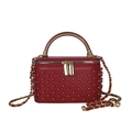 Detail of red leather box bag featuring rivet studs and gold metal round handle - Burgundy