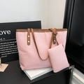 Rosa gewebtes Shopper-Set mit braunen Lederriemen und kleiner Tasche auf weißen Büchern - Rosa