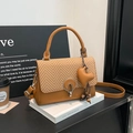 Bolso bandolera de cuero marrón con solapa trenzada y colgante de corazón sobre libros - Marrón con colgante