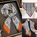 Dettaglio di un foulard in raso zebrato con bordo caramello mostrato in vari stili - Leopardo a Righe/Stampa Zebra