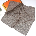 Macro detail of leopard print silk scarf showing lightweight fabric texture and hem - Small Dot Leopard