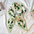 Detail of floral printed satin ribbon scarf showing elegant green leaf and red flower patterns - Tender Green Leaves
