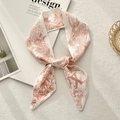 Close-up of a knotted floral twilly scarf with retro illustrations on white carpet - Letter X (Beige Brick Red Vintage Art)