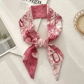 Detail of red and white French pastoral print silk scarf tied on a beige background - Letter U (Red and White Vintage Landscape)