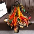 Detailed texture of silk scarf draped on luxury handbag with vintage abstract print - Green
