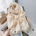 Dettaglio di sciarpa in cotone e lino color crema su un divano con trama del tessuto - Bianco Sporco