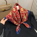 Detail of vintage silk scarf with golden floral patterns tied on a black sweater neck - Red Floral