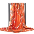 Detail view of orange silk scarf showing intricate gold chain and belt patterns with a satin finish - 90*90cm / Orange & Yellow