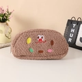 Detailopname van het zachte pluche koekjesetui met schattig borduursel en pluizige textuur - Bruin