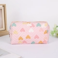 Close-up of quilted heart pattern and metallic zipper detail on a pink pencil case - Pink