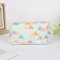 Detail of mint green quilted pencil case with colorful heart patterns and V-stitch texture - Blue