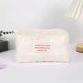 Detalle del estuche acolchado crema con patrones de corazón y etiqueta de tela - Blanco