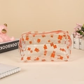 Close-up of waterproof transparent PVC pouch with orange clover patterns and a side handle - Clover (Orange)
