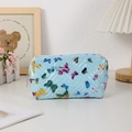 Détail du sac à cosmétiques bleu clair avec matelassage chevron et motifs de papillons - Bleu