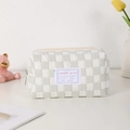Detailed close-up of quilted checkerboard pouch with metal zipper and woven label - Light Green