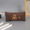 Primer plano de estuche marrón de tela Oxford con bonitos estampados de carpincho y cremallera - Estilo Sosteniendo Naranja