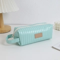 Detail van mintgroene gewatteerde etui met zijhandvat en Good Fortune lederen patch - Matchagroen