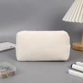 Vista dettagliata dell'astuccio bianco a trama waffle con tessuto morbido e cerniera - Beige