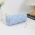Close-up of light blue quilted pencil case with textured bubble fabric and zipper closure - Blue