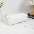 Close-up of white quilted pencil case with minimalist diamond stitching and soft texture - White