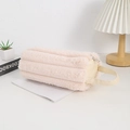 Macro-opname van pluchen pennenzak van roze nepbont met leren handvat op een bureau - Beige