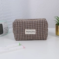 Macro view of checkered cosmetic bag with houndstooth pattern and zipper closure - Checkered Khaki