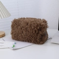 Macro view of plush brown lamb wool texture and metal zipper closure on pencil case - Coffee