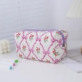 Dettaglio dell'astuccio trapuntato con stampa floreale, fiocchi rosa e zip viola - Viola