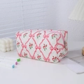 Dettaglio della trousse trapuntata con stampa di rose e fiocchi e cerniera rosa - Rosa