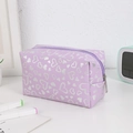 Detail of purple makeup bag with silver heart patterns and smooth zipper closure - Purple
